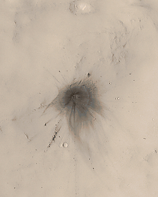 Colorized view of impact site; small crater at center of very extensive dark rays, rings, and chains of secondary pits.
